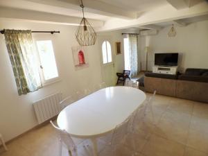 salon z białym stołem i krzesłami w obiekcie Piscine chauffée climatisation Wifi w mieście Six-Fours-les-Plages