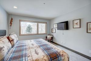 Schlafzimmer mit einem Bett, einem TV und einem Fenster in der Unterkunft Three-Bedroom Townhouse in Beaver Creek