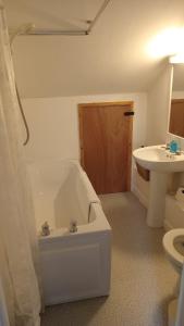 a bathroom with a tub and a sink and a toilet at Curlews Cottage - House with 3 bedrooms and garden - walking distance to the beach in Perranporth