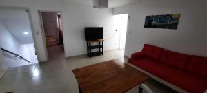 sala de estar con sofá rojo y TV en Casa en Bosque Peralta Ramos en Mar del Plata