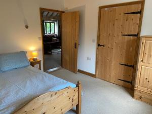 a bedroom with a bed and wooden cabinets at Wood Farm Barn in Laxfield