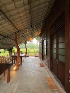 a porch of a house with benches and a tree at Ceylon Resort Wilpattu in Wilpattu