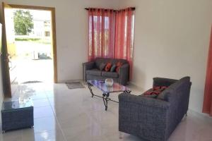 a living room with two couches and a glass table at Villa en Plantation, Puerto Plata in Muñoz