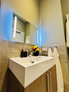 a bathroom with a white sink and a mirror at Blue City Apartment’s in Hamburg