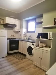 a kitchen with white cabinets and a washer and dryer at La Casetta in San Maurizio Canavese