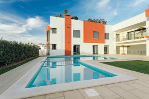 a swimming pool in front of a house at Best Houses 23: Stunning Apartment, Great Location in Ferrel