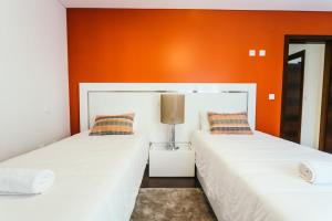two beds in a room with an orange wall at Best Houses 23: Stunning Apartment, Great Location in Ferrel +17 photos