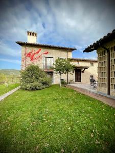 dom z trawnikiem przed nim w obiekcie Agriturismo Casale Montebello w mieście Monteleone di Spoleto