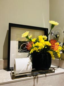 een vaas met bloemen op een tafel voor een spiegel bij Blue City Apartment’s in Hamburg