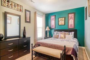 Schlafzimmer mit einem Bett, einer Kommode und einem Spiegel in der Unterkunft Palm Oaks Estate in Myrtle Beach