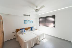 a white room with a bed and a ceiling fan at Aligio Apart-hotel & Spa - Las Terrenas in Las Terrenas