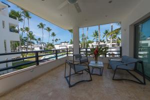a balcony with two chairs and a table at Aligio Apart-hotel & Spa - Las Terrenas in Las Terrenas