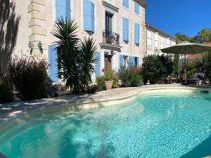 a large swimming pool in front of a building at Maison du Midi, 2 Gîtes de charme in Ginestas