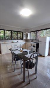 a kitchen with a table and chairs and a refrigerator at Hiraya Apart in Puerto Iguazú