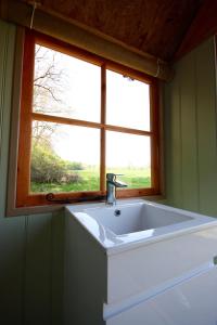 a sink in a bathroom with a window at Willow Yurt in Fernhurst