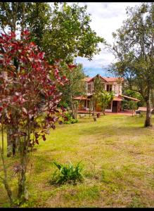 a house in the middle of a yard with trees at Hermosa casa para vacaciones en San José de Suaita in San José de Suaita