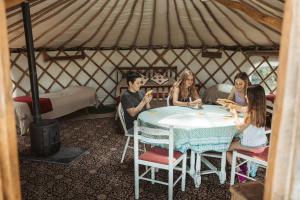 a group of people sitting around a table in a yurt at Willow Yurt in Fernhurst