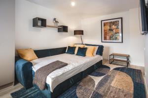 a bed in a room with a blue couch at Bearsleys Knights Apartments in Rīga