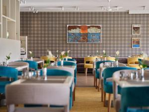 コルスヴァントにあるDorint Resort Baltic Hills Usedomのダイニングルーム(青いテーブル、黄色い椅子付)