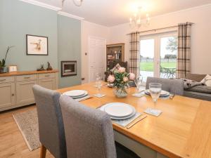 a dining room and living room with a table and chairs at Brundall House in Norwich