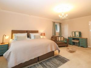 1 dormitorio con 1 cama grande y 1 silla en Brundall House en Norwich