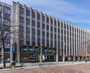 un gran edificio con una motocicleta estacionada frente a él en Rotterdam's coolest apartment, en Róterdam
