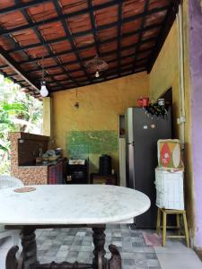 a kitchen with a table and a refrigerator at Recanto da Nara in Pipa