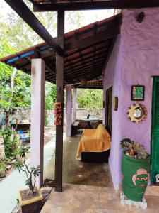 Habitación con cama en una casa rosa en Recanto da Nara, en Pipa