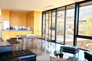 un salon avec une table et des chaises et une cuisine dans l'établissement Villa Garven @ R. Encuentro Guadalupe, à Valle de Guadalupe 43 autres photos