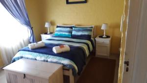 a bedroom with a bed with blue and white sheets at Yellow Submarine in Franskraal