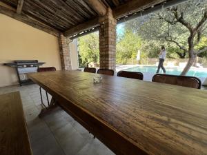 a large wooden table in a room with a pool at Demeure du Dragon 5 chambres Piscine- 10 lits - personnes in Saint Jean du Pin