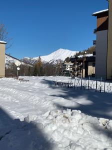 Un parking couvert de neige avec une montagne en arrière-plan dans l'établissement Casa Olivera, à Limone Piemonte