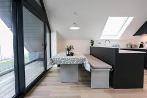 a dining table in a kitchen with a large window at Ocean View - Bracklesham Bay in Chichester