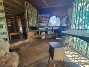 een kamer met een tafel en stoelen en boeken bij Derek's Place Eco-Lodge in Little Corn Island