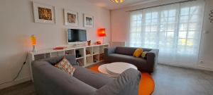 a living room with two couches and a tv at La Villa Pop in Joué-lès-Tours