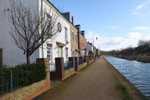 a row of houses next to a river at Ideal Coach House in Swindon