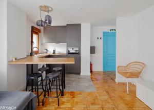 Una cocina con encimera y taburetes en una habitación. en AV Cervantes 2 Centro, en Gijón