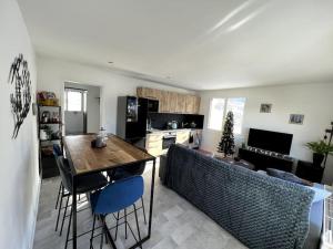 een keuken met een tafel en stoelen in een kamer bij Appartement cocooning 2 chambres in Gourette