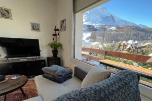 uma sala de estar com vista para uma montanha em Appartement cocooning 2 chambres em Gourette