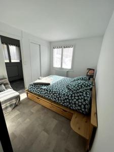 ein Schlafzimmer mit einem Bett in einem Zimmer mit Fenstern in der Unterkunft Appartement cocooning 2 chambres in Gourette