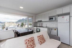 sala de estar con sofá y cocina en Walanika Apartamentos en Ushuaia