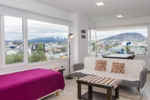 1 dormitorio con cama y ventana grande en Walanika Apartamentos en Ushuaia