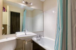 a bathroom with a sink and a tub and a mirror at Les Laurentides in Villarembert