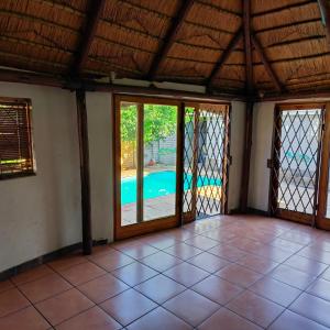 an empty room with sliding glass doors and a pool at No 12 in Rustenburg
