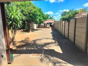an alley with a fence and trees and a building at No 12 in Rustenburg