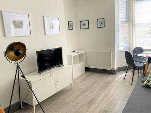 a living room with a flat screen tv on a dresser at The Four Bays Apartment - Cliftonville Central - By Goldex Coastal Breaks in Kent