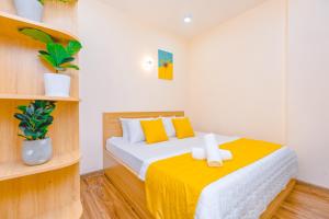 頭頓的住宿－Gold Sea Apartment Vung Tau-The Palm Sea View，一间卧室配有一张黄色毯子床
