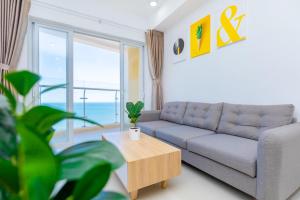 頭頓的住宿－Gold Sea Apartment Vung Tau-The Palm Sea View，客厅配有沙发和桌子