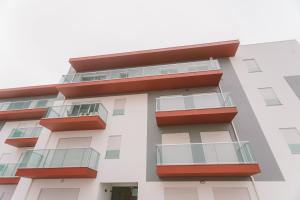 un edificio blanco con balcones rojos en Best Houses 25 - Seaside Retreat, en Peniche
