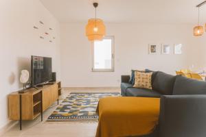 Una sala de estar con un sofá y un televisor. en Best Houses 25 - Seaside Retreat, en Peniche